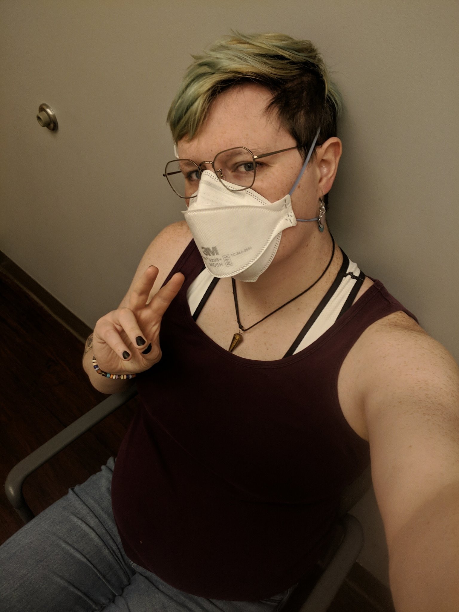 selfie of me. i am sitting in a chair and doing a peace sign. i look cute.