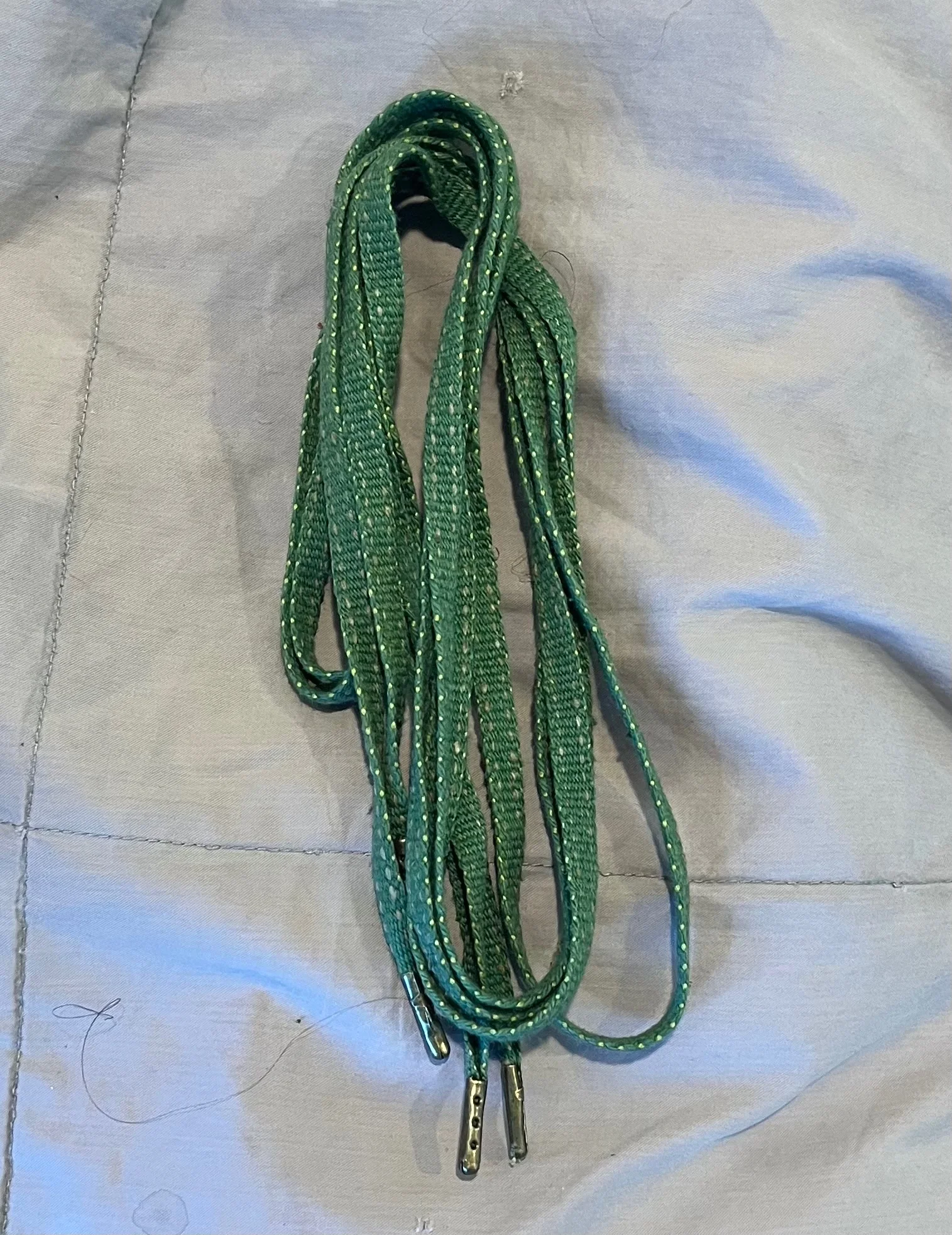 Handwoven green shoelaces with metal aglets 
